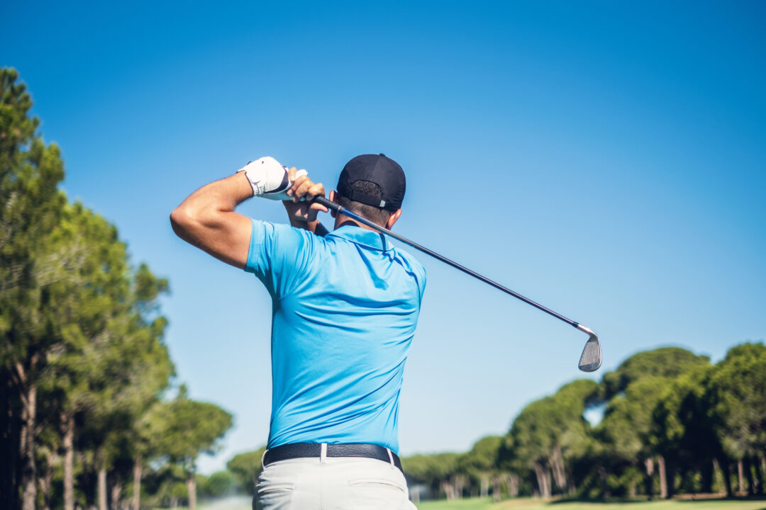 Man playing golf outdoors