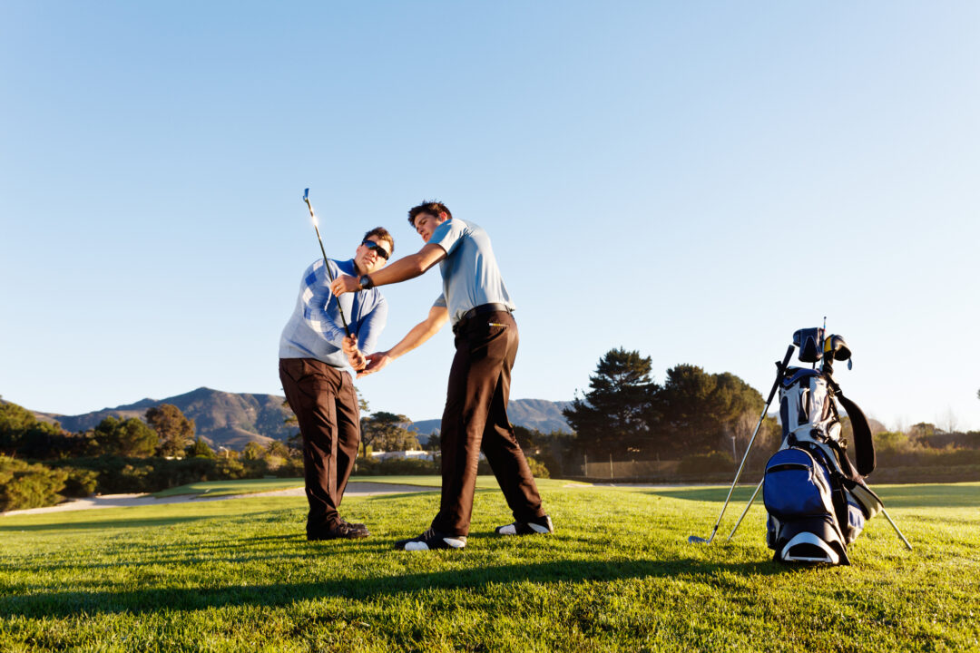Two golfers practicing on green