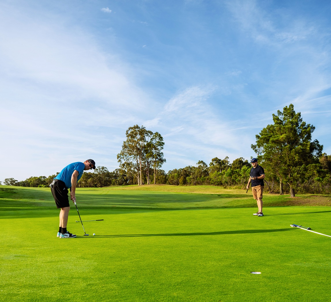 Golfers putting on a sunny course